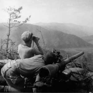 men from the 1st Marines scan surrounding hilltops for a suitable target