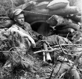 Henry M. Rector, 1st Marines, relaxes with his Browning .30 caliber machine gun.